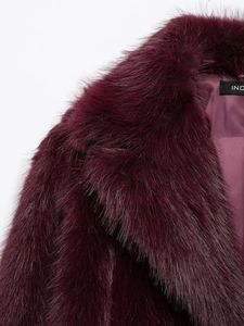 Gros plan sur la texture en fausse fourrure et la doublure en satin bordeaux du manteau