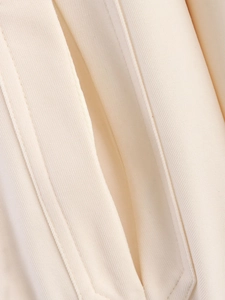 Detailed close-up of premium beige twill fabric with professional double stitching