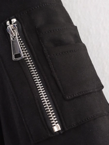 Detail von Silberreißverschluss und Utility-Tasche an schwarzer Fliegerjacke aus Wildleder