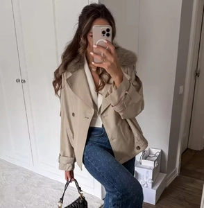 Detail of khaki cropped double-breasted trench coat with faux fur collar and adjustable straps