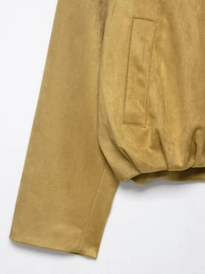 Détail d'un bomber en suédine ocre avec ourlet élastique et coutures sur la poche latérale