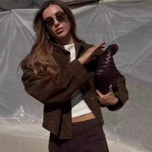 Bombardier femme en suédine marron foncé avec une pochette tissée et des lunettes