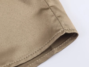 Detailed macro view of khaki twill fabric stitching on sleeve cuff with double needle seam