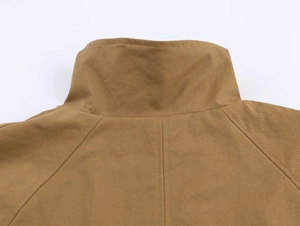 Close-up of khaki short jacket showing standing collar and twill fabric texture