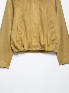Gros plan détaillé de la veste bomber en suédine montrant la texture et le bouton