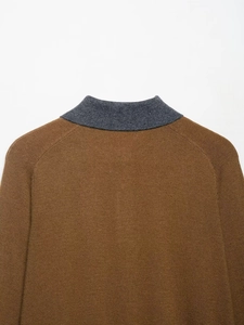 Detailed view of the brown knit fabric texture and grey ribbed collar of the polo shirt