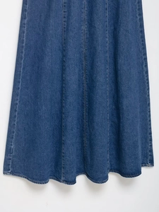 Detailed view of the paneled denim stitching and high-density fabric on a navy blue dress