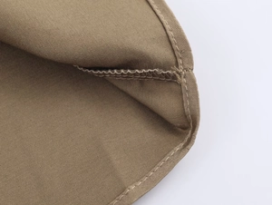 Detail of professional overlock stitching and seam work on khaki twill shirt fabric