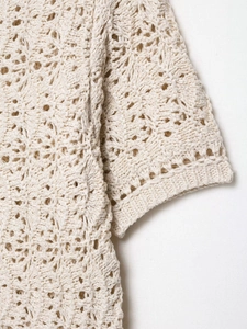 Gros plan du motif de crochet floral ajouré sur le haut en tricot crème