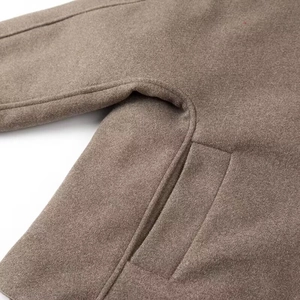 Detailed macro view of the side pocket and armpit stitching on brown wool jacket