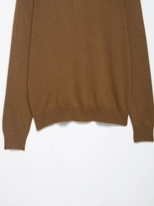 Detail of brown knit polo sweater showing rib-knit cuffs and soft texture fabric
