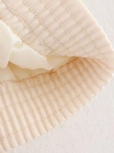 Macro shot of beige corduroy bucket hat brim with detailed reinforced stitching
