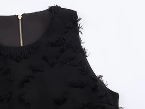 Detail of round neck black top with golden back zipper and 3D tufted fringe texture