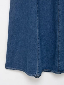 Close-up of dark blue denim dress featuring contrast double-stitching and fabric texture