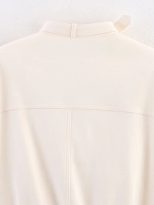 Close-up of the back yoke and fine stitching on the cream-colored loose jacket