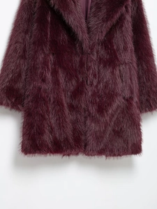 Vue détaillée de la texture en fausse fourrure violette et doublure soyeuse du manteau
