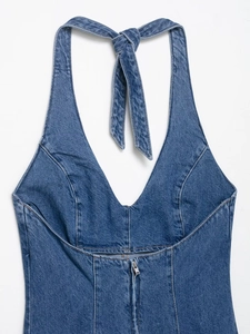 Detail view of denim halter top featuring a deep V-neckline and metal zipper accent
