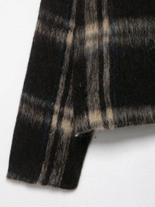 Close-up of the fuzzy plaid wool fabric showing the detailed brown and blue checkered texture
