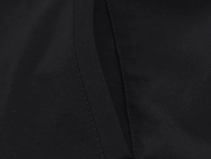 Detail of double stitching on minimalist black nylon puffer jacket showing fabric texture