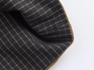 Detailed close-up of dark blue checkered lining and brown twill fabric on jacket