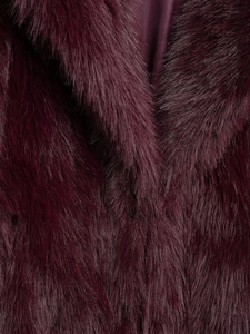 Détail d'un luxueux manteau en fausse fourrure bordeaux avec doublure satinée et col épais
