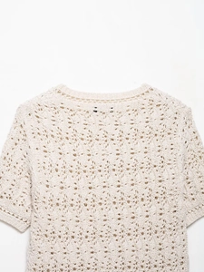 Vue détaillée du motif en maille crochetée crème et du col côtelé sur ce haut pour femme