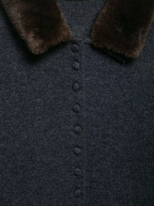 Detailed view of grey knit cardigan featuring brown faux fur collar and covered buttons