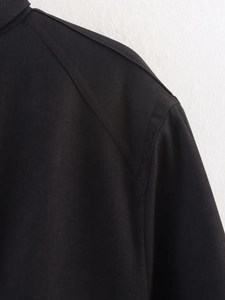 Close-up of the shoulder stitching and twill texture on a black loose jacket for women