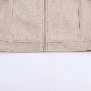 Detail of oatmeal wool blend jacket featuring a light gold zipper and neat stitching