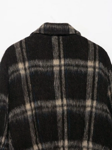 Close-up of deep-toned plaid wool blend fabric showing rich texture and stitching detail