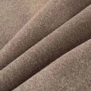 Macro close-up showing the premium wool texture and deep camel fabric of the V-neck coat