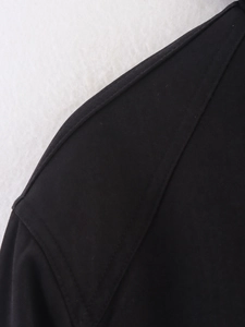 Detailed close-up of stitching and twill texture on a black casual jacket sleeve