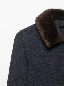 Close-up of luxury dark grey knit coat featuring a textured brown faux fur collar