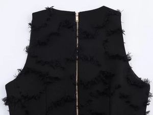 Detail of black fringe textured top featuring a premium gold metal zipper on the back