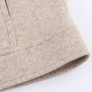 Close-up of soft oatmeal wool texture and premium stitched hem on the zipper jacket