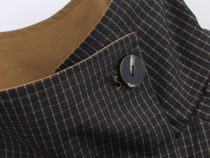 Detail of navy blue plaid coat with marble button and thick brown lining fabric texture