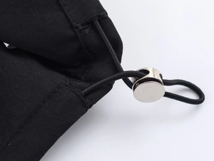 Close-up of adjustable elastic drawstring with silver metal cord lock on black jacket