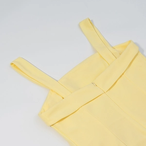 Détail d'une robe jaune pâle montrant des coutures précises et une fermeture éclair invisible
