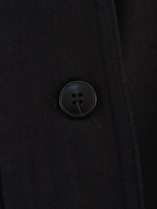 Close-up of black twill fabric texture and matching four-hole round button on jacket