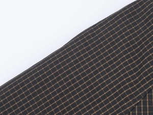 Macro shot of dark grey micro-plaid fabric with fine woven texture for stylish outerwear