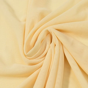 Détail du tissu en maille jaune clair montrant la texture fine et le drapé doux fluide