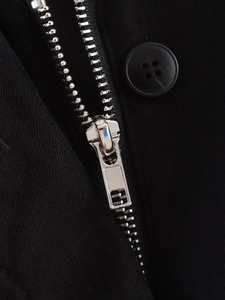 Macro shot of silver metal zipper and black button on textured twill fabric jacket