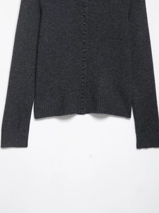 Close-up of charcoal grey knit cardigan featuring fabric buttons and ribbed texture details
