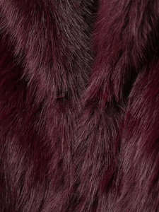 Vue macro de fausse fourrure bordeaux dense montrant une texture douce et un éclat naturel