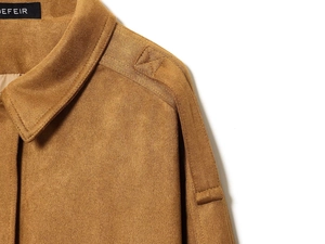 Close-up of brown suede jacket showing the notched lapel and decorative shoulder stitching