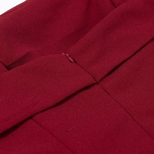 Détail en gros plan du tissu texturé rouge foncé avec une fermeture éclair invisible au dos