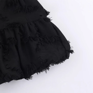 Elegant black top for women featuring chic fringe trim and textured raw hem detail