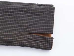 Detail of checkered fabric jacket with brown lining and professional split cuff stitching
