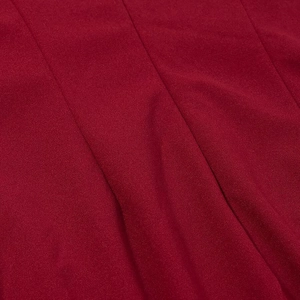 Détail du tissu tissé rouge foncé avec coutures visibles sur une robe longue dos nu sexy