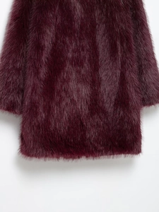 Détail du manteau long en fausse fourrure bordeaux montrant la texture douce et brillante